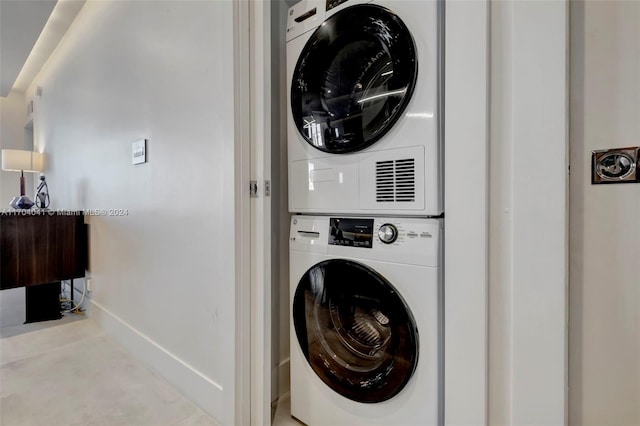 clothes washing area with stacked washer and clothes dryer