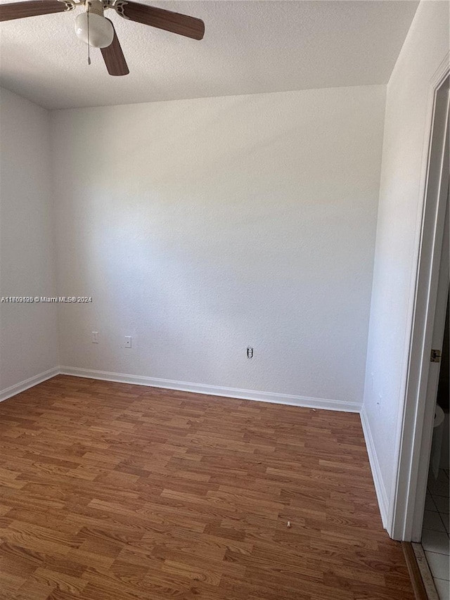 spare room featuring ceiling fan, dark hardwood / wood-style flooring, and a textured ceiling