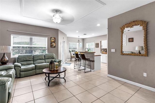 living room with ceiling fan, sink, and light tile patterned floors