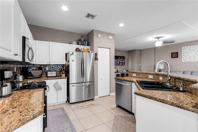 kitchen with decorative backsplash, sink, white cabinets, and appliances with stainless steel finishes