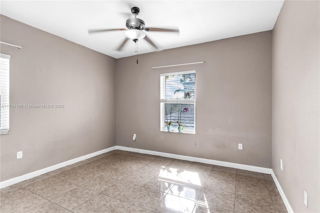 tiled spare room with ceiling fan