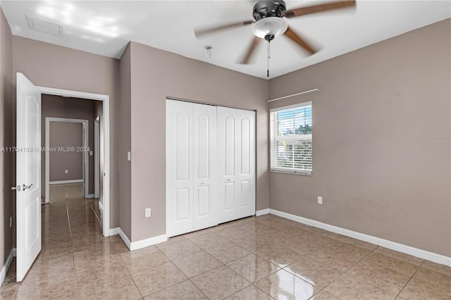 unfurnished bedroom with ceiling fan, light tile patterned floors, and a closet