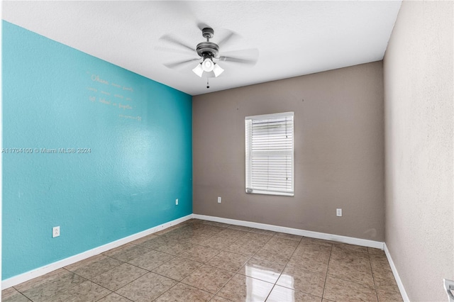 tiled spare room featuring ceiling fan