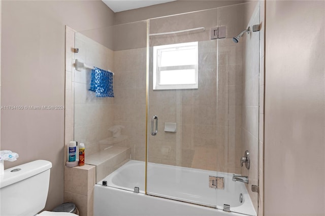 bathroom with shower / bath combination with glass door and toilet