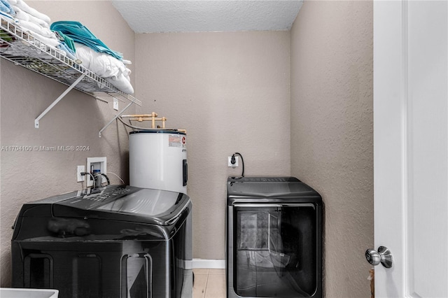 laundry room with electric water heater, tile patterned flooring, a textured ceiling, and independent washer and dryer