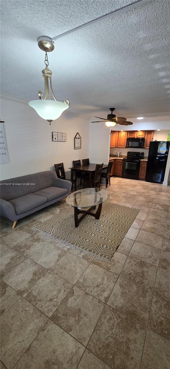 living room featuring a textured ceiling and ceiling fan