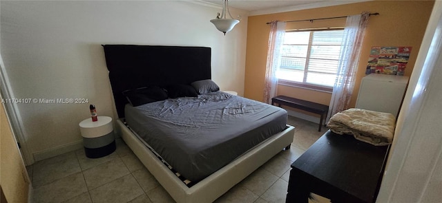 bedroom with light tile patterned floors and crown molding