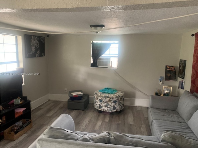 living room with hardwood / wood-style floors, a textured ceiling, and a wealth of natural light