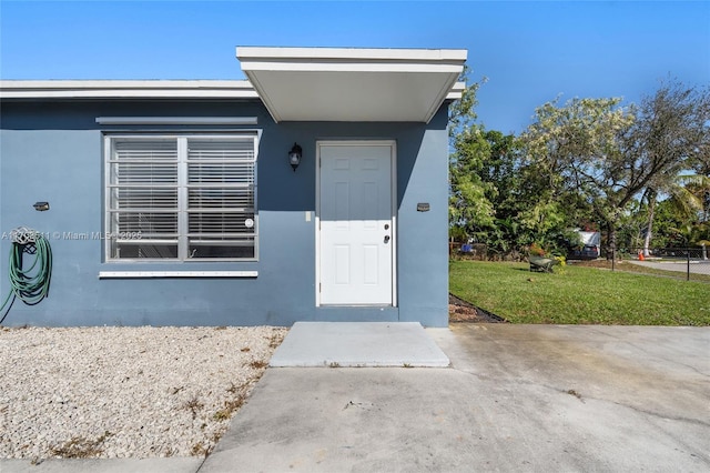 property entrance featuring a lawn