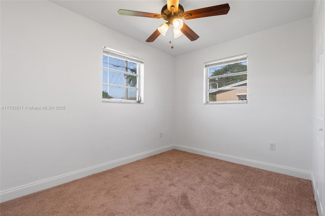 carpeted spare room featuring ceiling fan