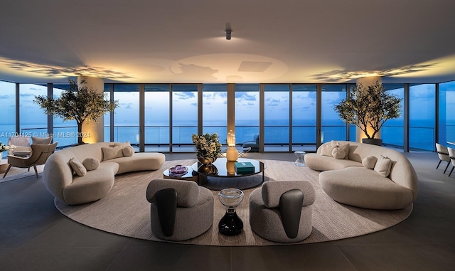 tiled living room featuring a water view and a wall of windows