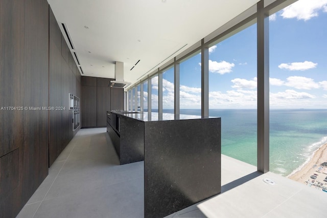 interior space with a beach view, a barn door, and a water view