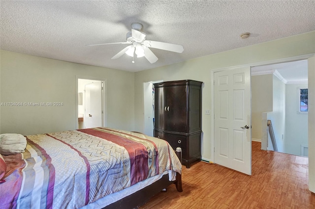 bedroom with a textured ceiling, hardwood / wood-style flooring, ceiling fan, and crown molding