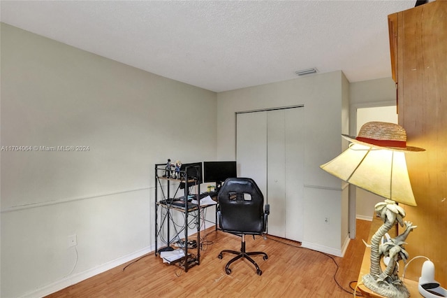 office area with hardwood / wood-style floors and a textured ceiling