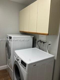 laundry area featuring washing machine and clothes dryer, dark wood-type flooring, and cabinets