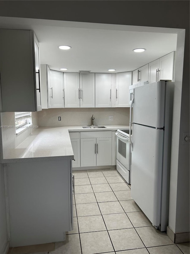 kitchen with white cabinetry, sink, light tile patterned floors, and white appliances