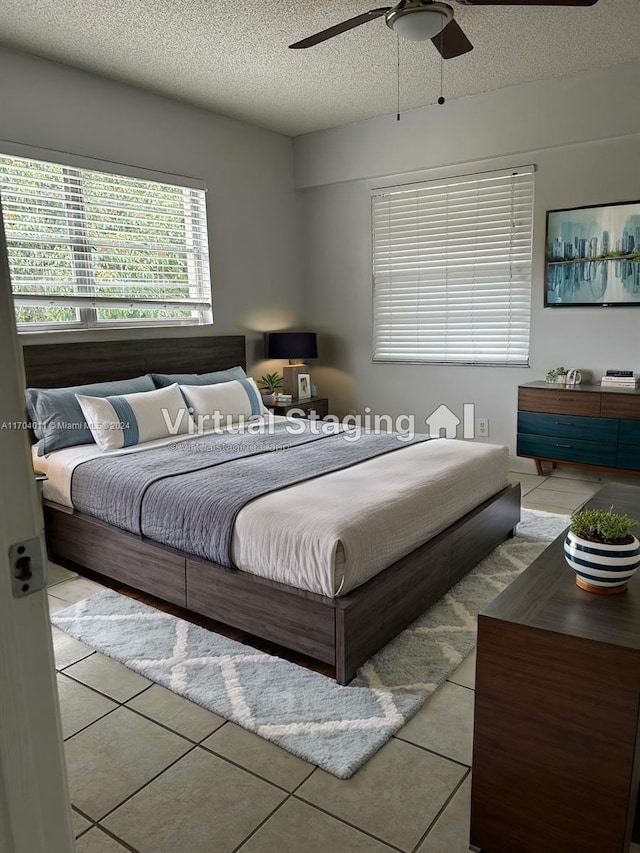 bedroom featuring light tile patterned floors, a textured ceiling, and ceiling fan