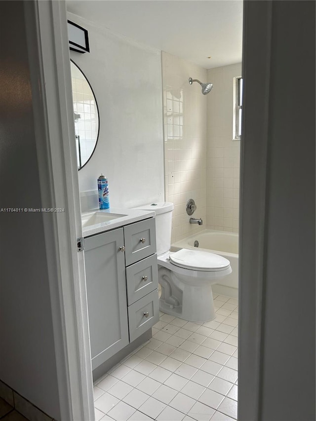 full bathroom featuring vanity, tiled shower / bath combo, tile patterned floors, and toilet