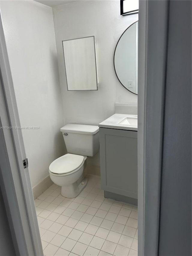 bathroom with tile patterned flooring, vanity, and toilet