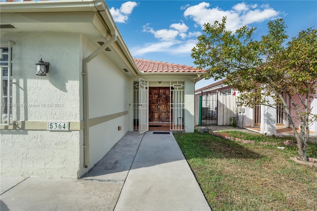 entrance to property featuring a lawn