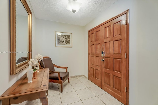 foyer with light tile patterned floors and a textured ceiling