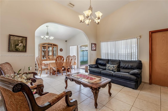 tiled living room featuring high vaulted ceiling and an inviting chandelier