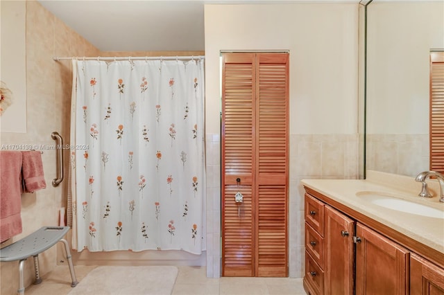 bathroom featuring tile patterned flooring, shower / bath combo, vanity, and tile walls