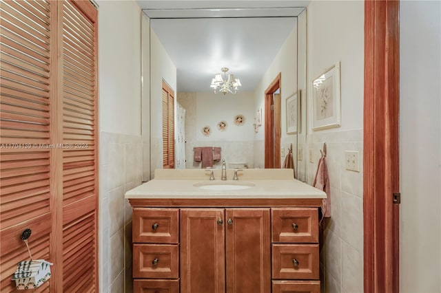 bathroom featuring vanity, tile walls, and a chandelier