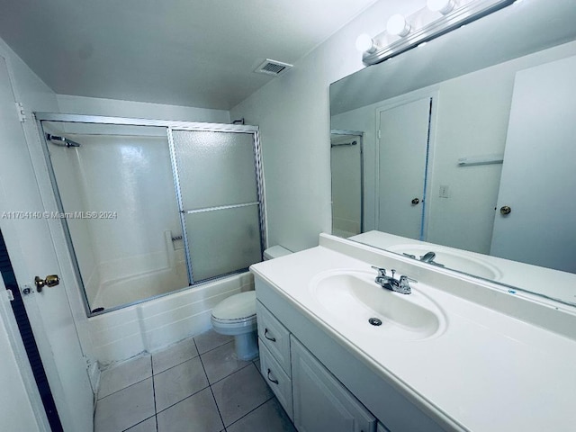 full bathroom with tile patterned flooring, combined bath / shower with glass door, toilet, and vanity