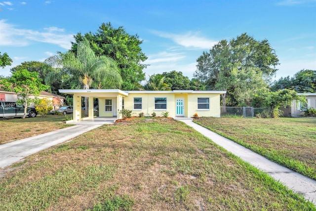 ranch-style home featuring a carport and a front yard