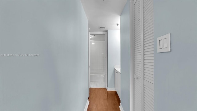 corridor with hardwood / wood-style flooring