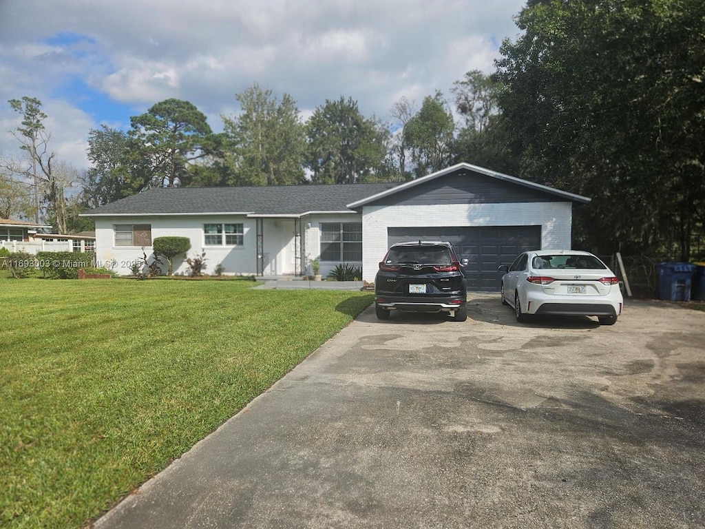 ranch-style home with a front yard, driveway, and an attached garage