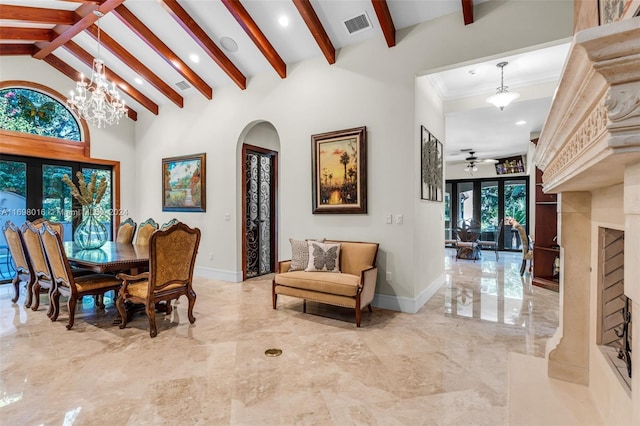 dining area featuring ornamental molding, ceiling fan with notable chandelier, beam ceiling, high vaulted ceiling, and a fireplace