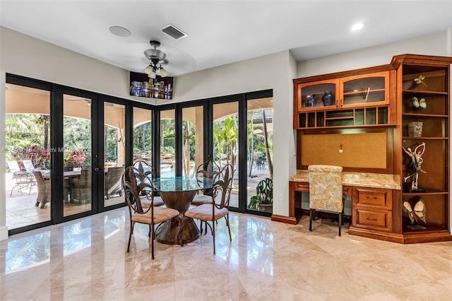 dining room featuring ceiling fan, built in desk, and french doors