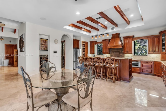 dining space with beam ceiling and a healthy amount of sunlight