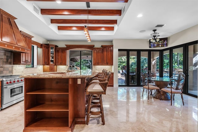 kitchen with custom exhaust hood, decorative backsplash, stainless steel range, and french doors