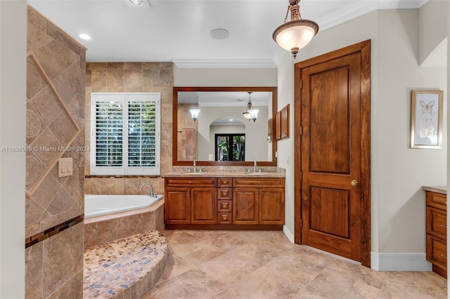 bathroom featuring tiled bath, vanity, a chandelier, and ornamental molding