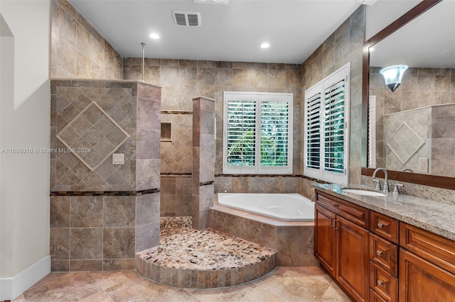 bathroom featuring vanity, plus walk in shower, and tile walls