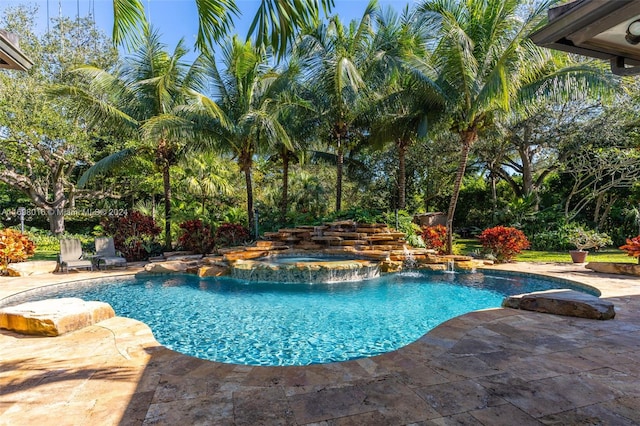 view of pool featuring an in ground hot tub, pool water feature, and a patio