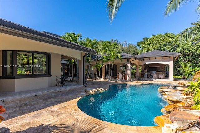 view of swimming pool with a patio area and exterior kitchen