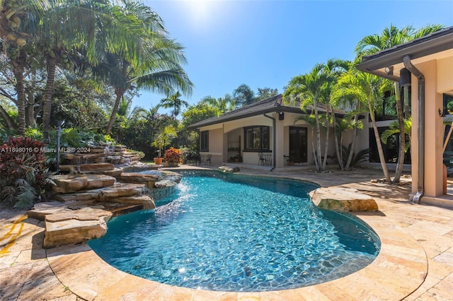 view of swimming pool with a patio and pool water feature