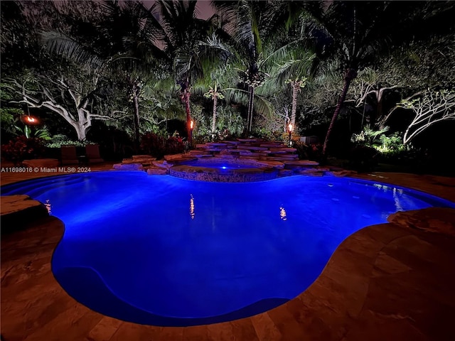 view of pool at twilight