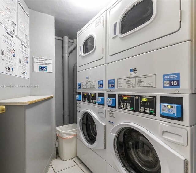 washroom with independent washer and dryer, stacked washing maching and dryer, and light tile patterned floors