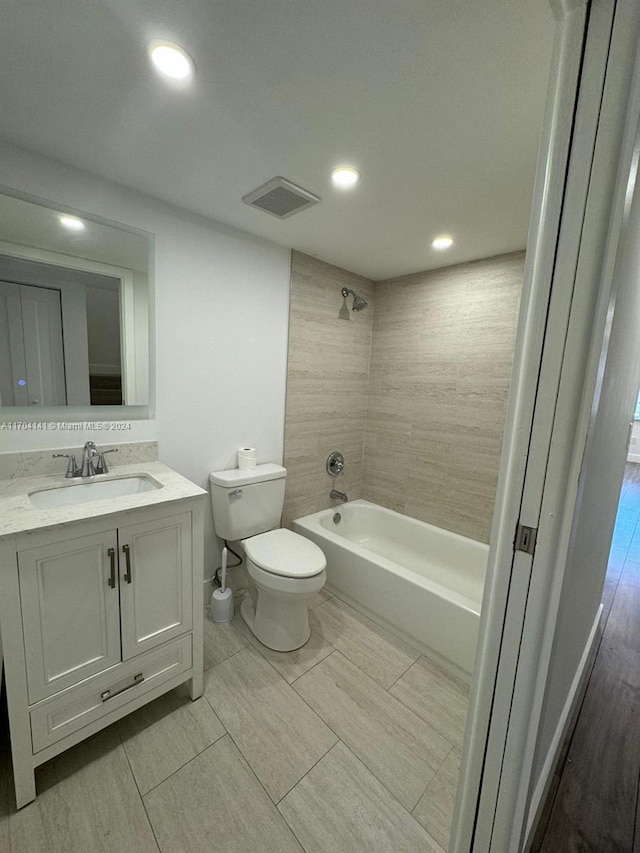 full bathroom with vanity, tiled shower / bath combo, and toilet