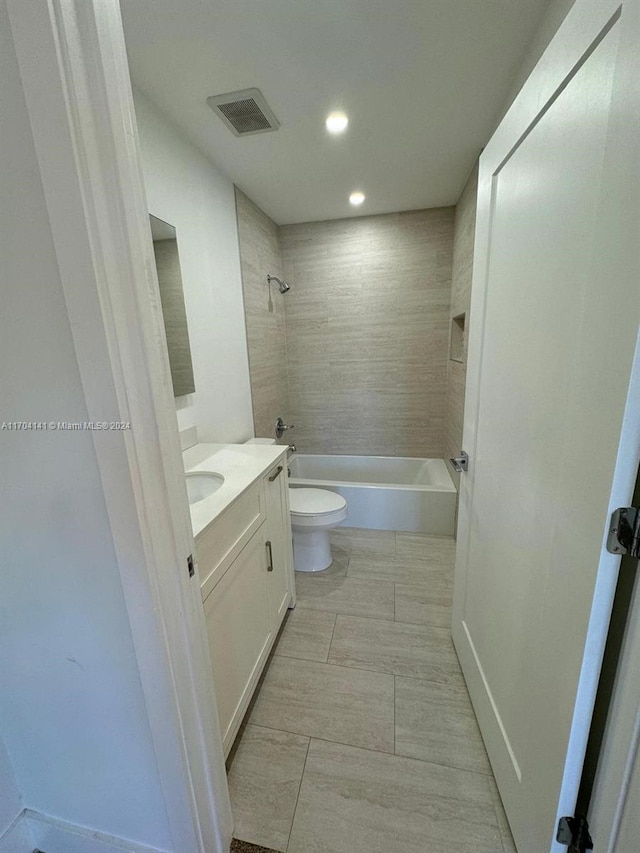 full bathroom featuring vanity, toilet, and tiled shower / bath combo