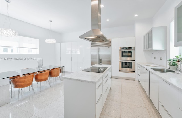 kitchen featuring island range hood, stainless steel appliances, sink, white cabinetry, and hanging light fixtures