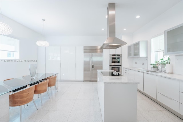 kitchen with island exhaust hood, stainless steel appliances, white cabinetry, and hanging light fixtures