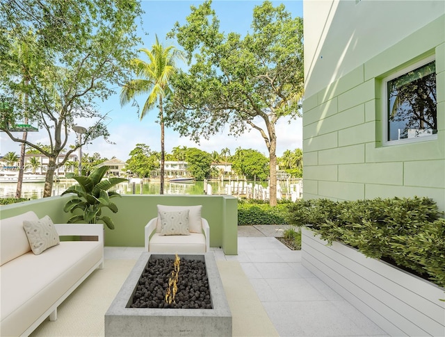 view of patio featuring a water view and an outdoor living space with a fire pit