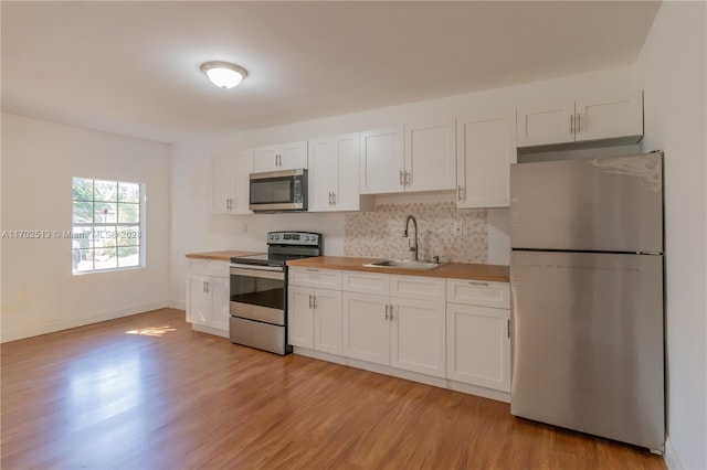 kitchen featuring white cabinets, stainless steel appliances, light hardwood / wood-style floors, and sink