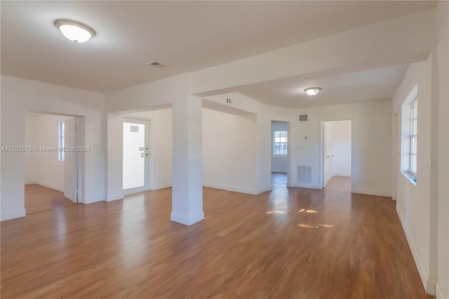 unfurnished room featuring plenty of natural light and wood-type flooring